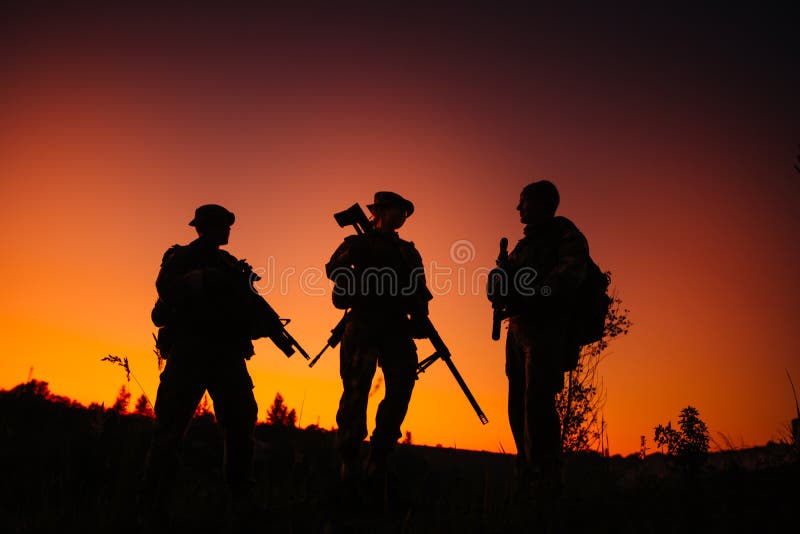 Siluetta dei soldati militari con le armi alla notte colpo, HOL immagini stock libere da diritti Siluetta dei soldati militari con le armi alla notte colpo, HOL immagini stock libere da diritti