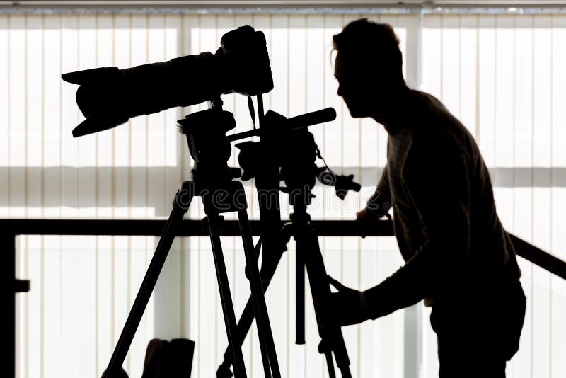 Siluetta del fotografo e del cineoperatore fotografia stock Siluetta del fotografo e del cineoperatore fotografia stock