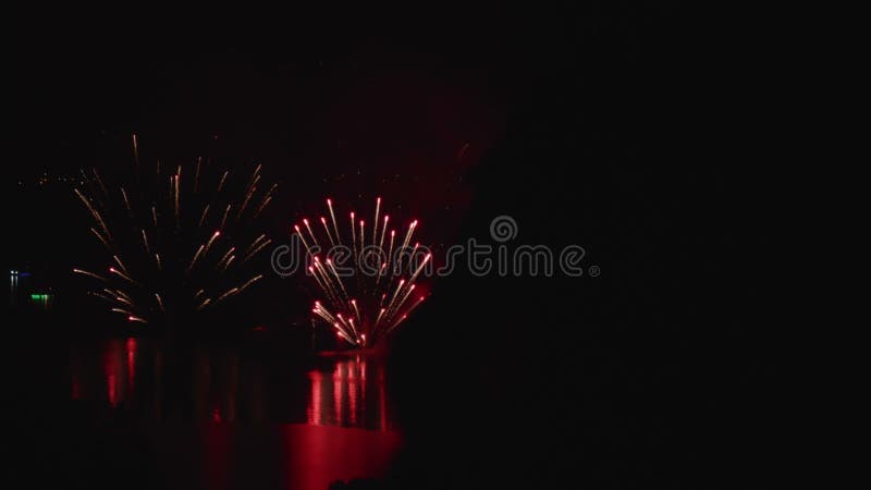 Siluetta dell'acqua di notte dell'esposizione dei fuochi d'artificio