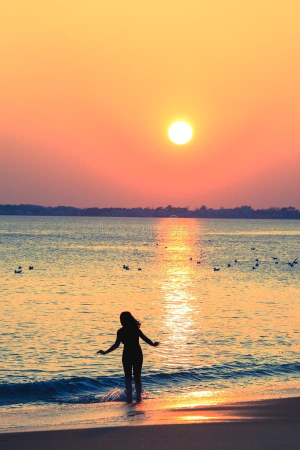 Siluetta della donna esile sulla spiaggia fotografia stock libera da diritti Siluetta della donna esile sulla spiaggia fotografia stock libera da diritti