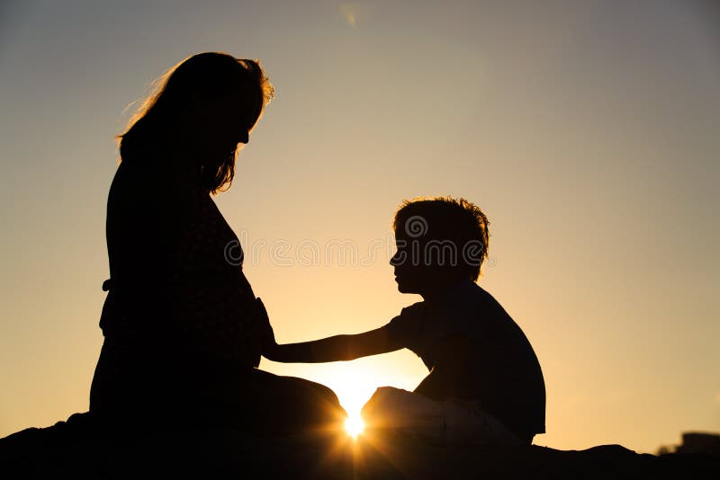 Siluetta della pancia incinta commovente della madre del ragazzino fotografie stock libere da diritti Siluetta della pancia incinta commovente della madre del ragazzino fotografie stock libere da diritti