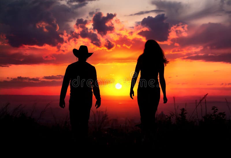 Siluetta delle coppie del cowboy al tramonto fotografia stock libera da diritti Siluetta delle coppie del cowboy al tramonto fotografia stock libera da diritti