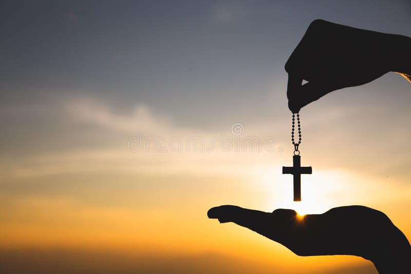 Siluetta di tenuta a mano coscia crocefisso di fondo tramonto Concetto per cristiano, cristianesimo, religione cattolica, dio