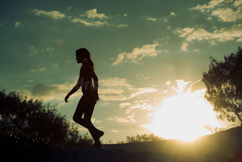 Siluetta di una ragazza al tramonto immagine stock Siluetta di una ragazza al tramonto immagine stock