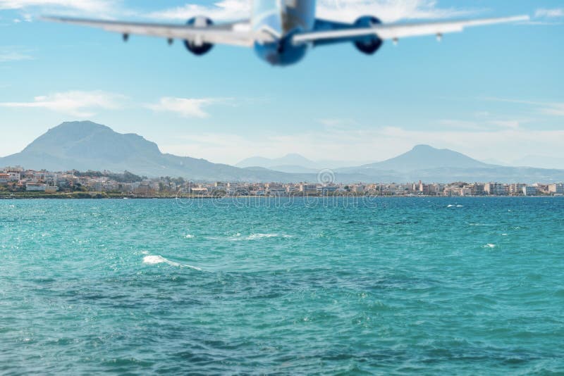 Siluetta vaga dell'aeroplano che sorvola il mare e la spiaggia immagine stock Siluetta vaga dell'aeroplano che sorvola il mare e la spiaggia immagine stock