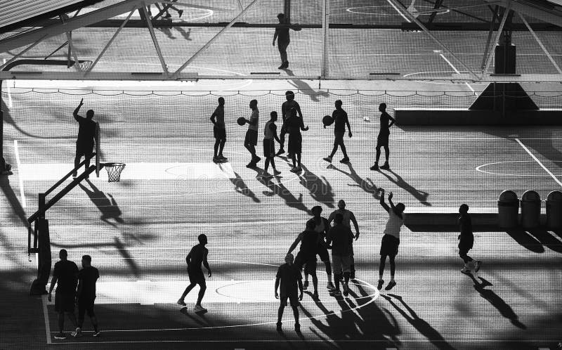 Siluette dei giocatori di pallacanestro al tramonto, New York immagini stock libere da diritti Siluette dei giocatori di pallacanestro al tramonto, New York immagini stock libere da diritti