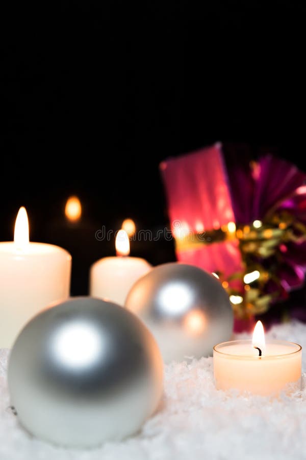 Silver christmas balls, candles and a red gift in the snow royalty free stock photography Silver christmas balls, candles and a red gift in the snow royalty free stock photography