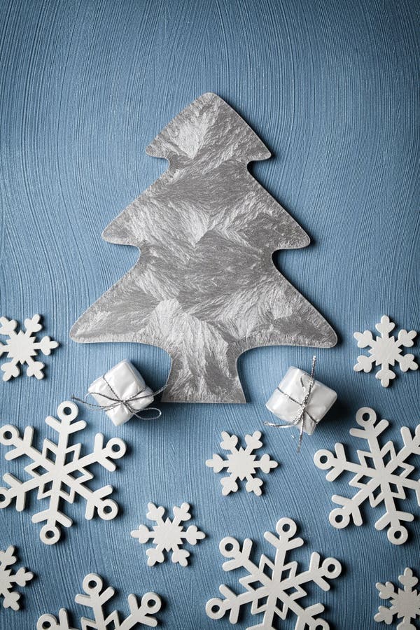 Christmas tree, snowflakes and gifts on blue background