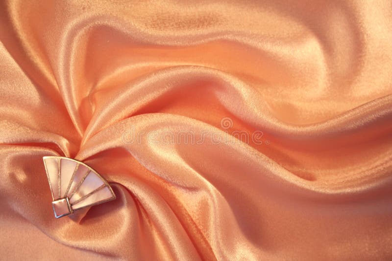 Silver fan from nacre on the elegant pink silk