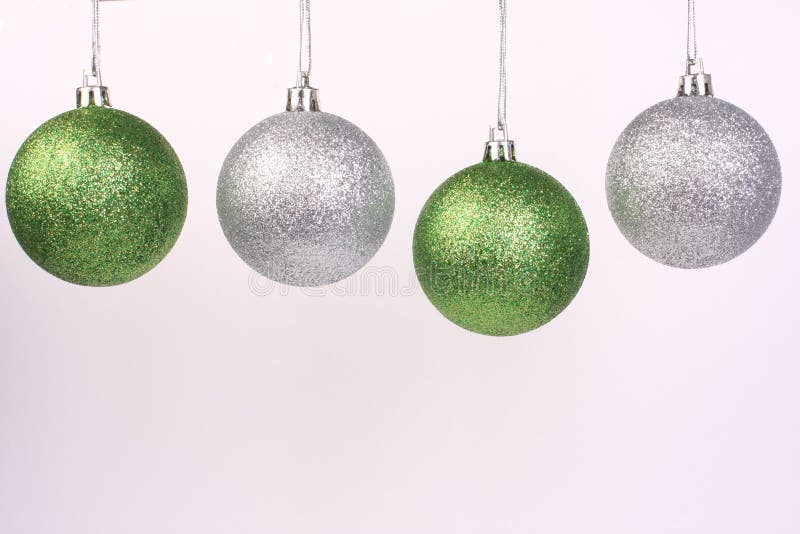 Green and sliver ornaments hanging together. Green and sliver ornaments hanging together