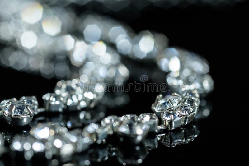 Silver necklace with diamonds close-up in defocus on a black background royalty free stock photography Silver necklace with diamonds close-up in defocus on a black background royalty free stock photography