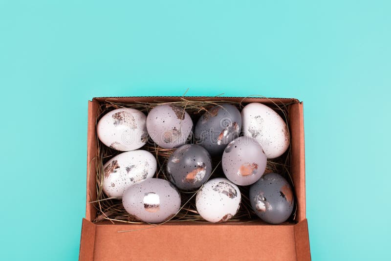 Silver Painted Decorative Eggs in Wooden Box on Pastel Blue Background