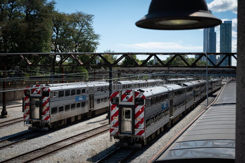 Passenger Trains Traveling through a Bustling Train Yard with a Clear