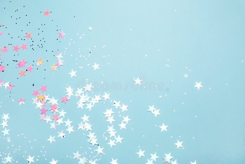 Silver and pink star glitter on blue pastel background.