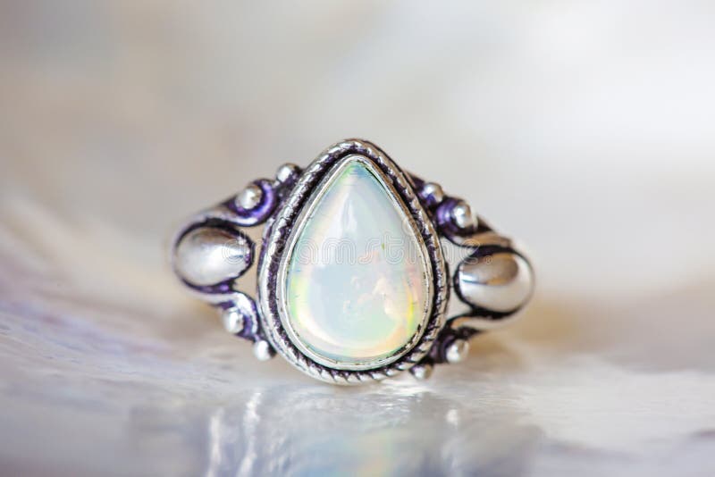 Silver ring with opal mineral gemstone on pearl background