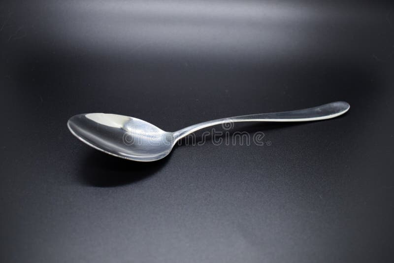 Silver spoon. cutlery set against dark background with a soft shodows closeup cooking dining black dine dinner food kitchen meal metal. Silver spoon. cutlery set against dark background with a soft shodows closeup cooking dining black dine dinner food kitchen meal metal
