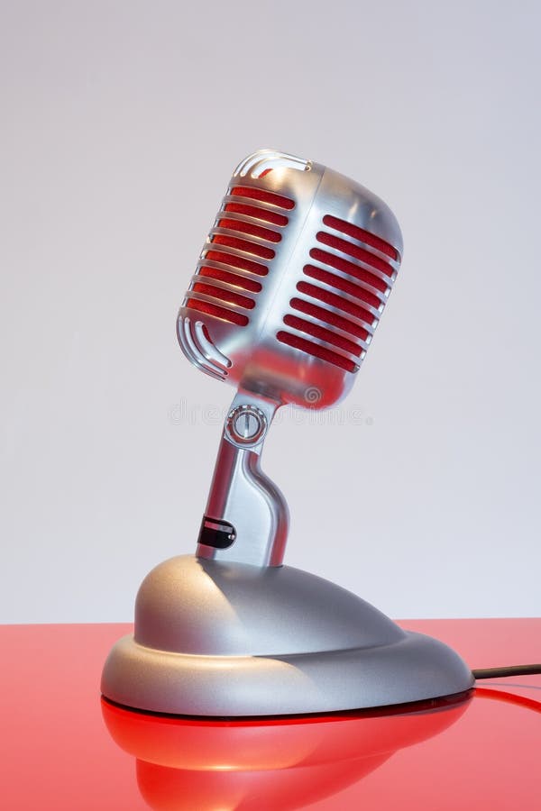 Silver Vintage Microphone with Red Membrane on a Red Table Stock Image
