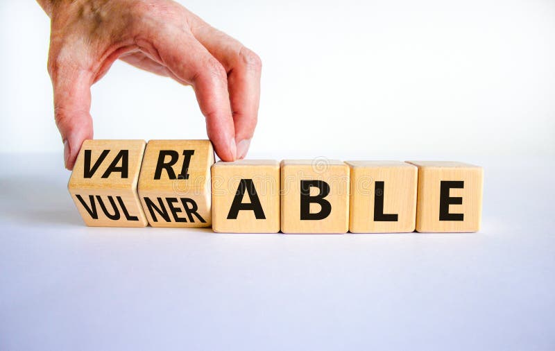 Simbol vulnerabil sau variabil. om de afaceri transformă cuburi de lemn și schimbă cuvântul vulnerabil la variabila. alb frumos stock photography