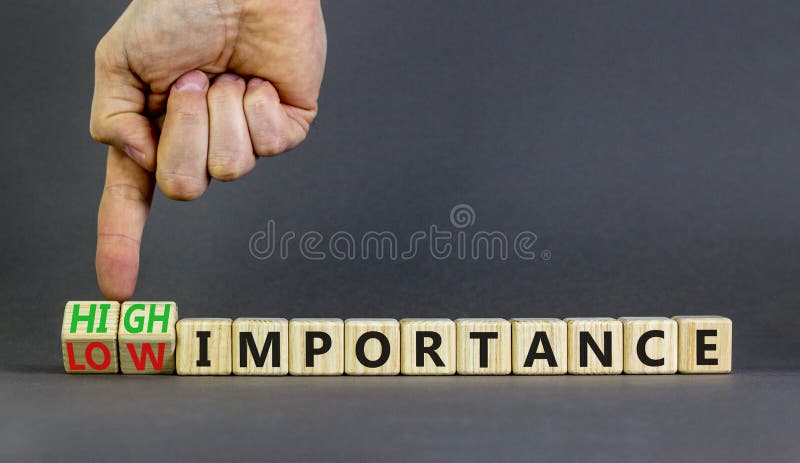 High or low importance symbol. Concept words High importance and Low importance on wooden cubes. Businessman hand. Beautiful grey background. Business high or low importance concept. Copy space. High or low importance symbol. Concept words High importance and Low importance on wooden cubes. Businessman hand. Beautiful grey background. Business high or low importance concept. Copy space