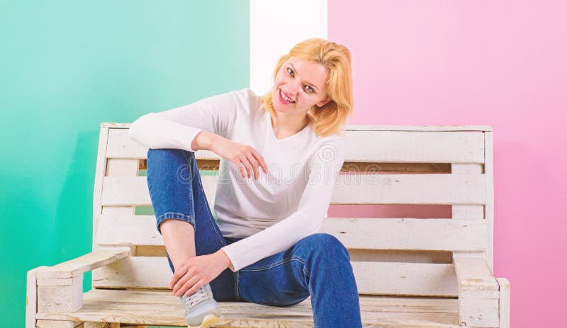 Simple beauty. She is simply gorgeous. Beautiful young woman smile while sitting on bench against pink background. Girl royalty free stock photos Simple beauty. She is simply gorgeous. Beautiful young woman smile while sitting on bench against pink background. Girl royalty free stock photos