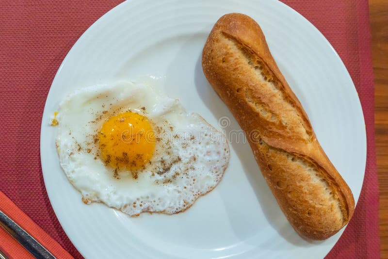 Simple Breakfast Meal with Sunny Egg and Loaf of Bread Stock Photo