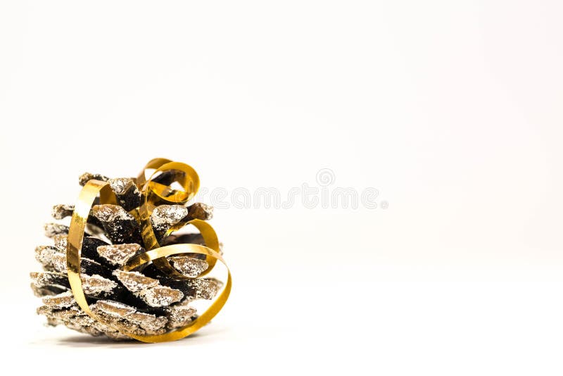 Simple Christmas image, pine cone with golden ribbon close up shot