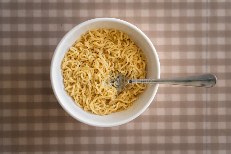 Simple cooked instant noodles on a checkered tablecloth stock images