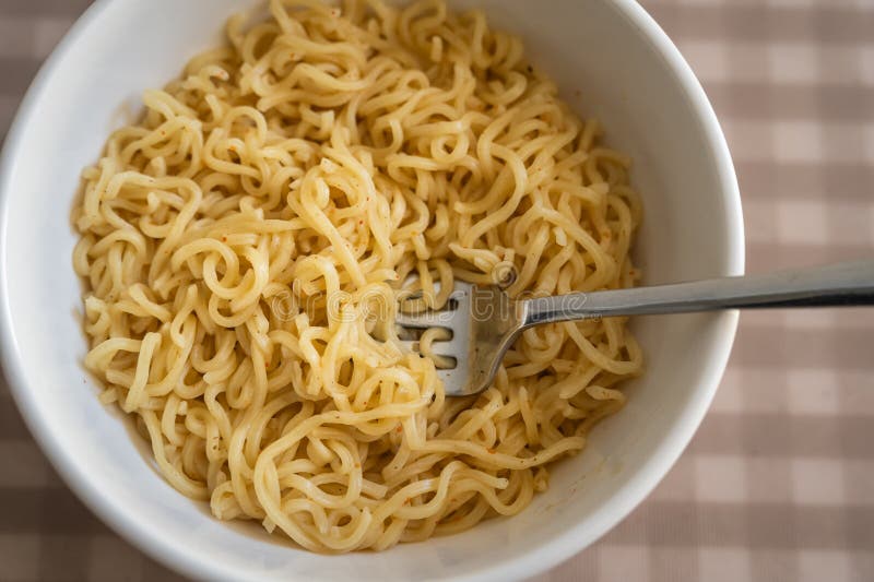 Simple cooked instant noodles on a checkered tablecloth royalty free stock images
