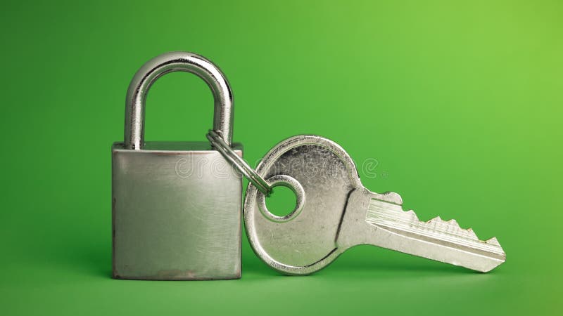 Simple lock and key. Small worn padlock with over large shiny key. Business data encryption, home security, or other safeguarding royalty free stock image