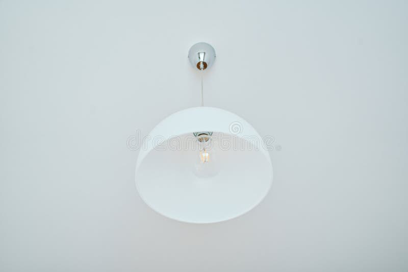 Minimalist White Ceiling Lamp with Exposed Lightbulb stock photo