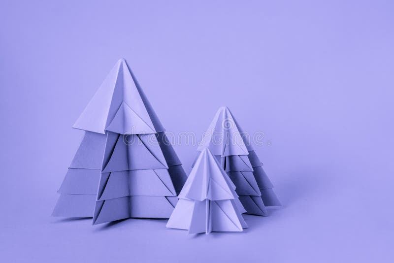 Simple origamy 3D Christmas tree made from paper toned yellow color