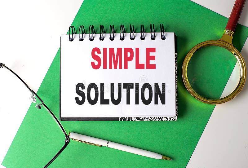 SIMPLE SOLUTION text on a notebook on green paper