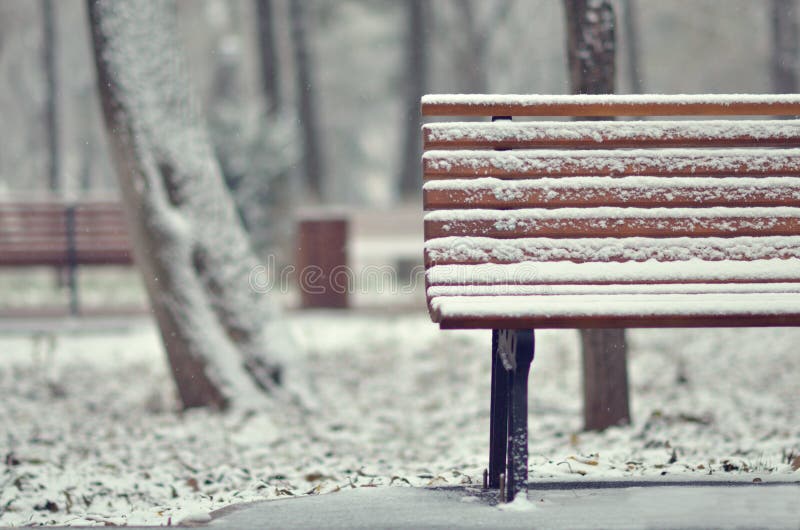 Simple wooden bench in snowy stock image