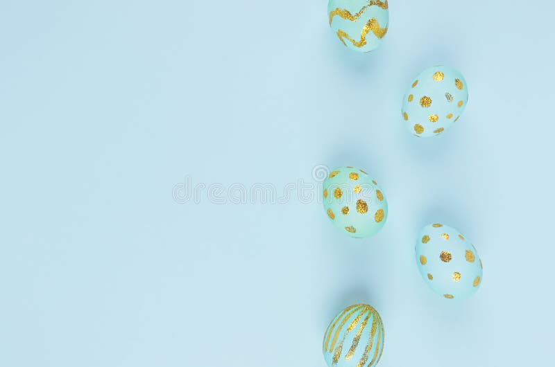Simplicity and minimal easter background - blue eggs with gold design as border on blue color, top view. royalty free stock image