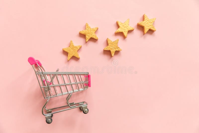 Simply flat lay design small supermarket grocery push cart for shopping and 5 gold stars rating isolated on pink pastel background