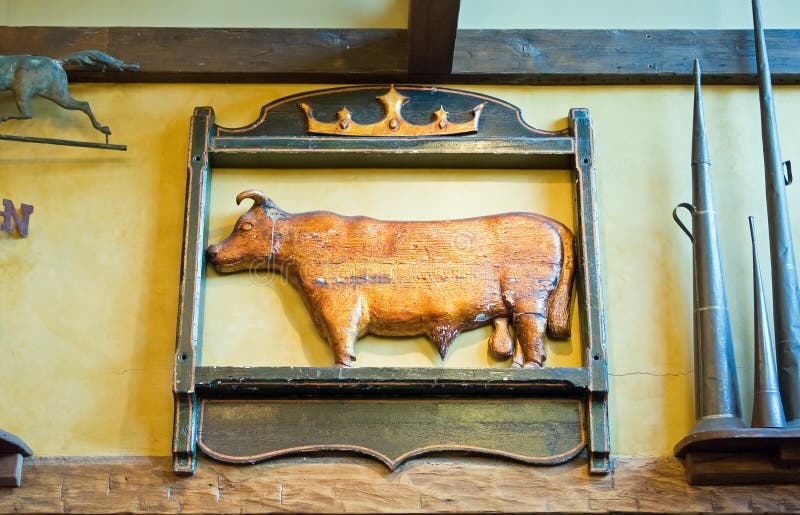 An antique wooden sign of a cow or bull used as a decorative farmhouse wall hanging. An antique wooden sign of a cow or bull used as a decorative farmhouse wall hanging.