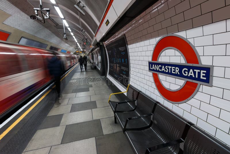 Sinal subterrâneo de Londres com trem e os povos moventes em Lancaste imagens de stock Sinal subterrâneo de Londres com trem e os povos moventes em Lancaste imagens de stock
