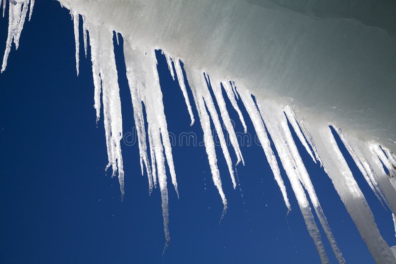 Melting long icicles hanging from the ceiling of an ice cave. Melting long icicles hanging from the ceiling of an ice cave