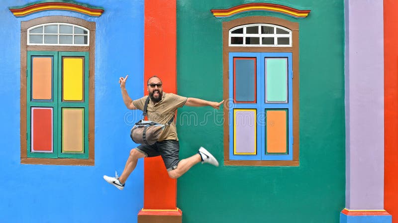 20.08.2017.Singapore, flying happy tourist in front of colorful facade of historic old building in Little India