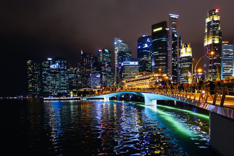 Singapore skyline noaptea. Vedere de noapte din golful marin cu parașutiști luminați și pod în centrul orașului Singapore.