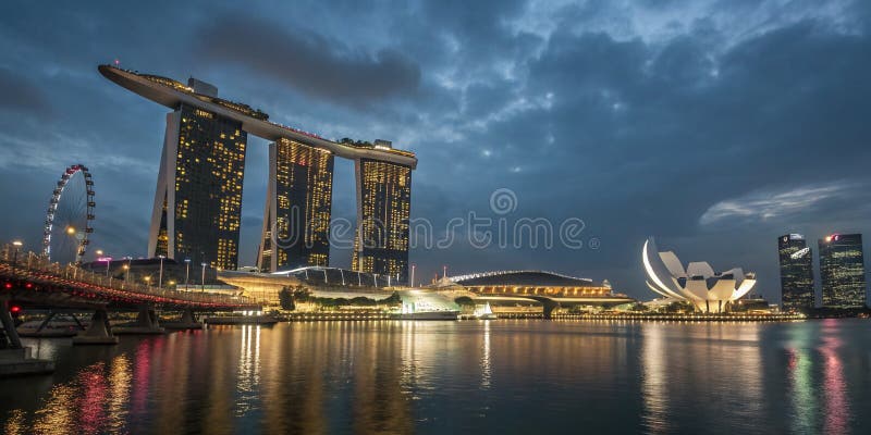 Marina Bay Sands w Singapurze nocą: Zapierający dech w piersiach widok świateł miasta, nowoczesnej architektury i odbijającego pię ilustracja wektor
