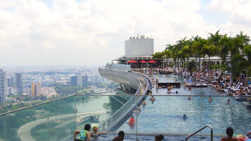 SINGAPOUR - 1er avril 2015 : Piscine d'infini de dessus de toit chez Marina Bay Sands Skypark, avec des personnes détendant au photographie stock SINGAPOUR - 1er avril 2015 : Piscine d'infini de dessus de toit chez Marina Bay Sands Skypark, avec des personnes détendant au photographie stock