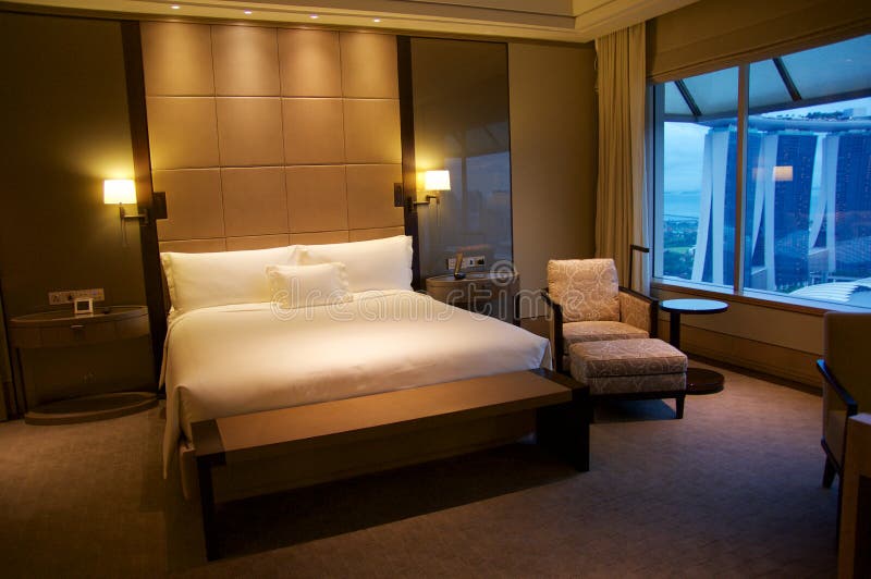 SINGAPURA - 23 de julho de 2016: sala de hotel de luxo com interior moderno, uma cama confortável e uma vista impressionante do p imagens de stock SINGAPURA - 23 de julho de 2016: sala de hotel de luxo com interior moderno, uma cama confortável e uma vista impressionante do p imagens de stock
