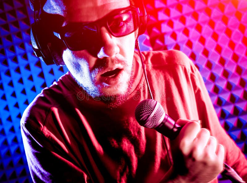 The singer sings with a microphone in the recording studio. stock photography