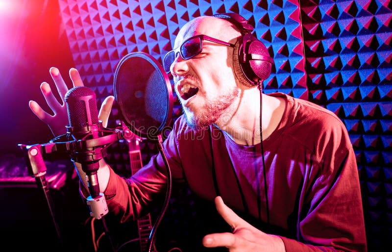 The singer sings with a microphone in the recording studio. royalty free stock images