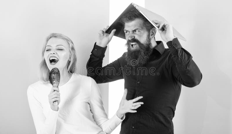 Singing is her passion. Lady sing using hair brush as microphone while man annoyed hiding under laptop. Better sing at.