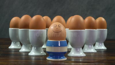 https://thumbs.dreamstime.com/b/single-boiled-egg-striped-egg-cup-smiling-face-front-group-eggs-white-egg-cups-rack-focus-shot-boiled-167205249.jpg?w=400