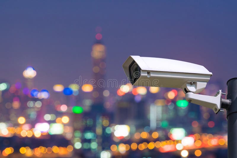 Single CCTV Security camera on Blurred night downtown city