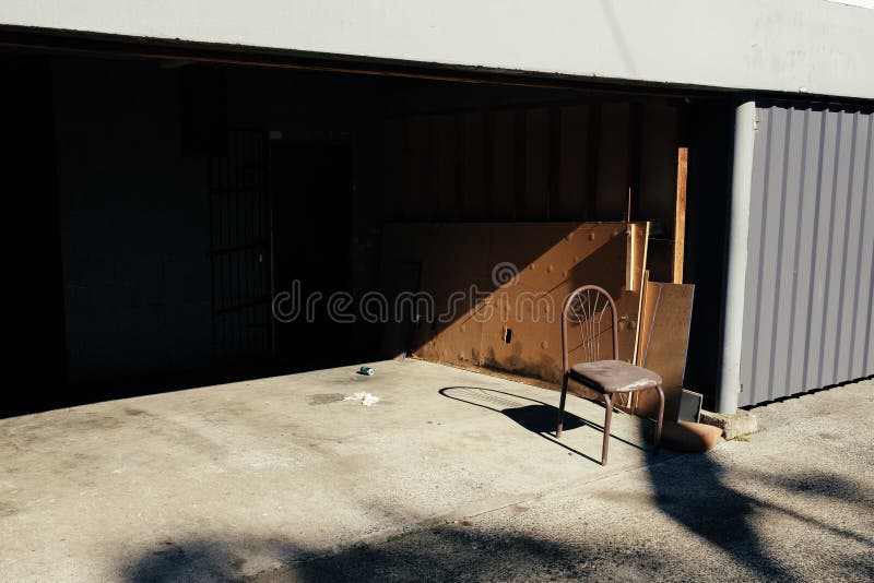A Single Chair in Front of a Garage Stock Photo Image of filled