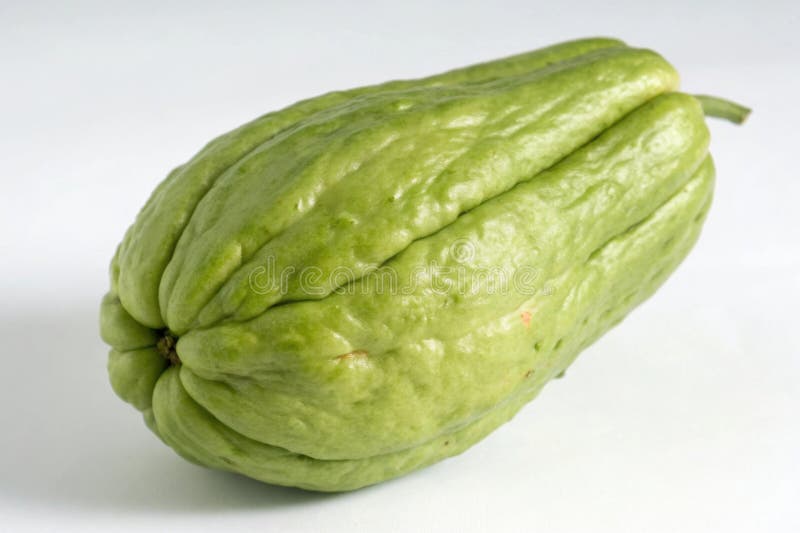 Single chayote cucumber showcasing unique texture and shape in bright light. A single chayote cucumber rests against a light background, highlighting its distinctive wavy skin and vibrant green color. Its unique shape and texture emphasize its freshness and ripeness. AI generated